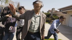 Satoshi Nakamoto is surrounded by reporters as he leaves his home in Temple City, California